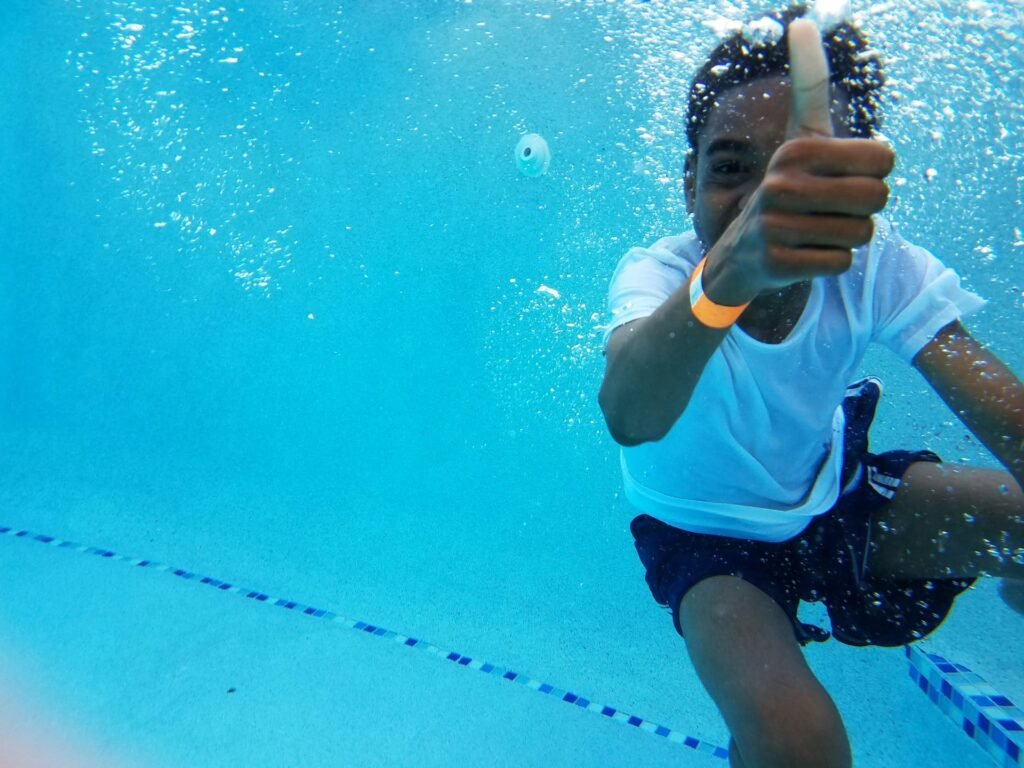 Under water photography of boy showing thumb